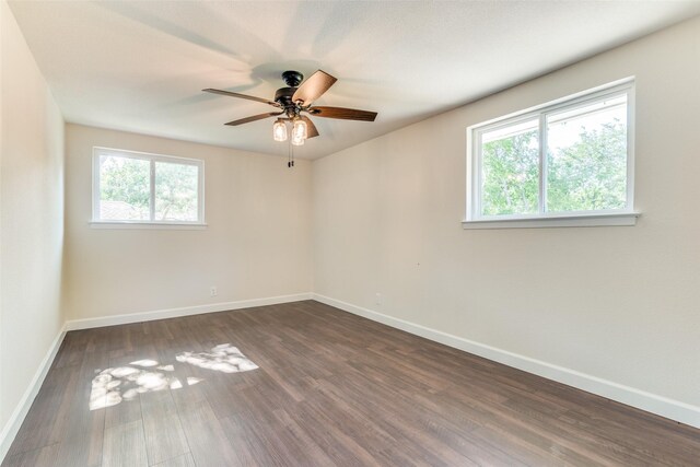 unfurnished room with plenty of natural light, ceiling fan, and dark wood-type flooring