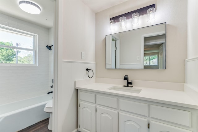 full bathroom with vanity, tiled shower / bath, hardwood / wood-style floors, and toilet