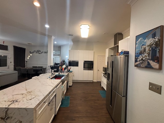 kitchen with sink, a center island with sink, ornamental molding, stainless steel appliances, and white cabinets