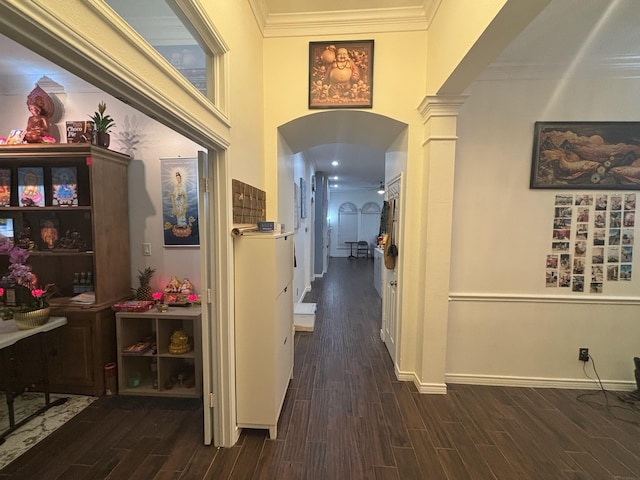 corridor with decorative columns, ornamental molding, and dark hardwood / wood-style flooring