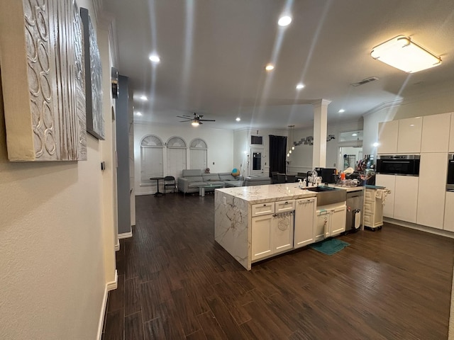 kitchen featuring sink, white cabinetry, light stone counters, dark hardwood / wood-style flooring, and oven