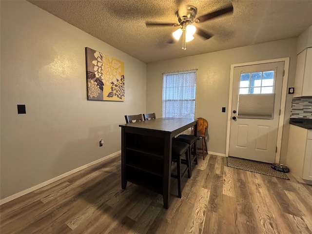 home office featuring ceiling fan, dark wood-type flooring, and a textured ceiling