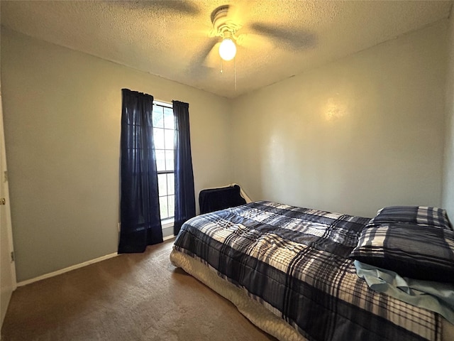 bedroom featuring dark colored carpet, ceiling fan, and a textured ceiling