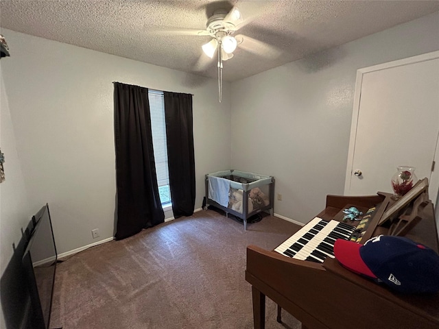 bedroom with ceiling fan, carpet floors, and a textured ceiling