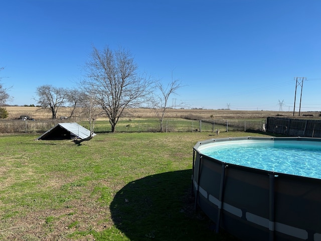 view of yard with a rural view and a fenced in pool