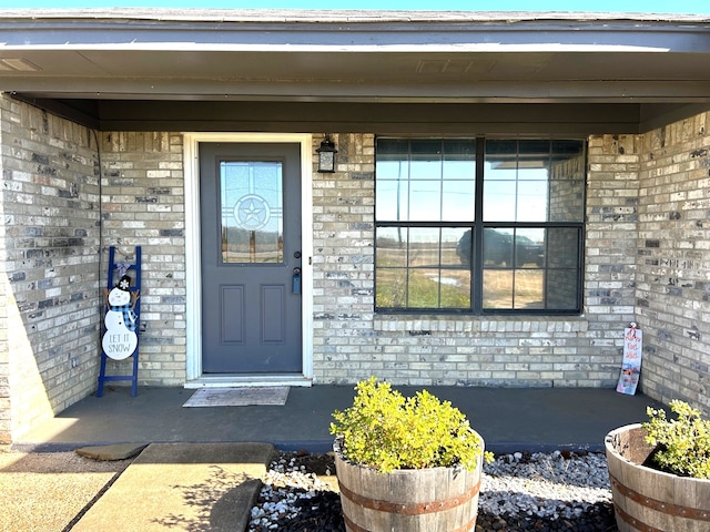 view of exterior entry featuring covered porch