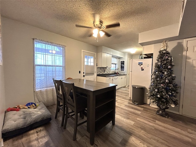 kitchen with sink, wood-type flooring, white cabinets, white appliances, and backsplash