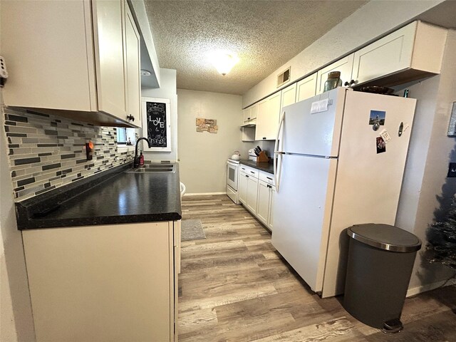 kitchen featuring white cabinetry, sink, white appliances, and light hardwood / wood-style floors