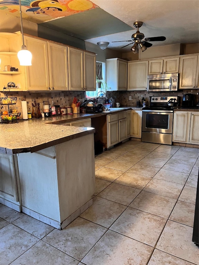 kitchen featuring decorative light fixtures, ceiling fan, kitchen peninsula, appliances with stainless steel finishes, and light tile patterned floors