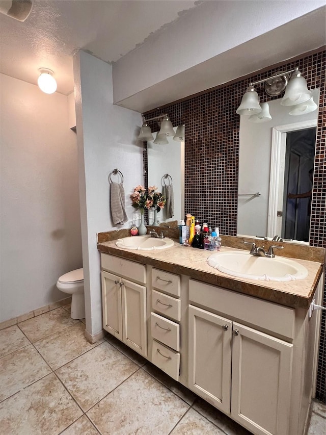 bathroom featuring toilet, vanity, tile patterned flooring, and a textured ceiling