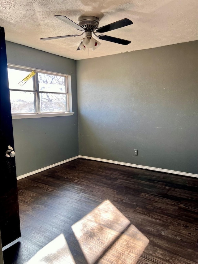 unfurnished room with ceiling fan, a textured ceiling, and dark hardwood / wood-style flooring