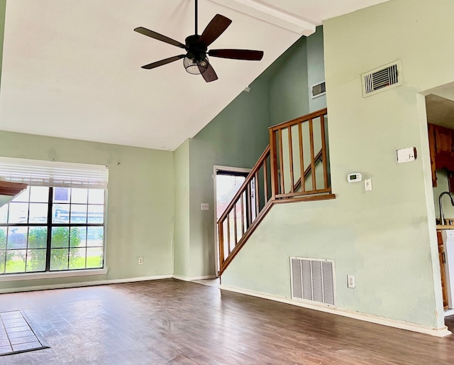 unfurnished living room with ceiling fan, sink, wood-type flooring, high vaulted ceiling, and beamed ceiling