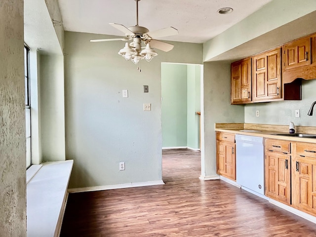 kitchen featuring white dishwasher, ceiling fan, light wood-type flooring, and sink