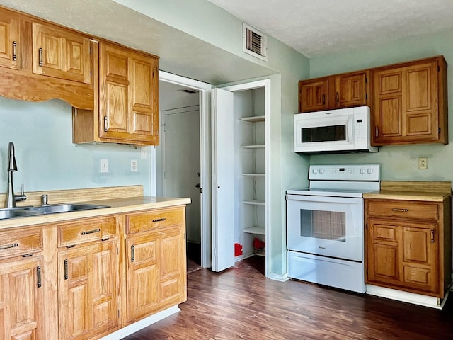 kitchen with dark hardwood / wood-style flooring, white appliances, a textured ceiling, sink, and built in features