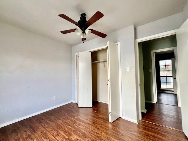 unfurnished bedroom with dark hardwood / wood-style flooring, a closet, and ceiling fan