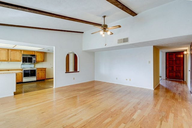 unfurnished living room with beamed ceiling, ceiling fan, light hardwood / wood-style floors, and a high ceiling