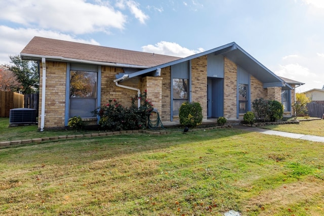 single story home featuring a front lawn and central air condition unit