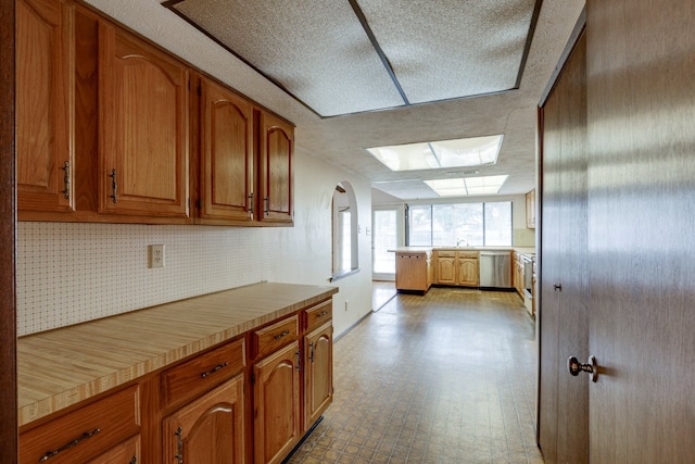 kitchen featuring dishwasher, a textured ceiling, and tasteful backsplash