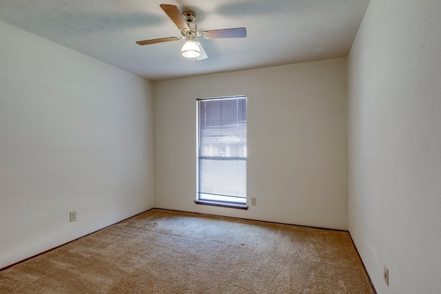 carpeted empty room with ceiling fan and a textured ceiling