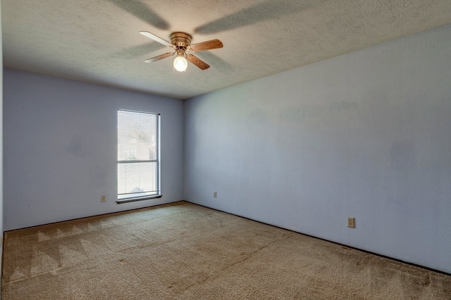 carpeted spare room with a textured ceiling and ceiling fan