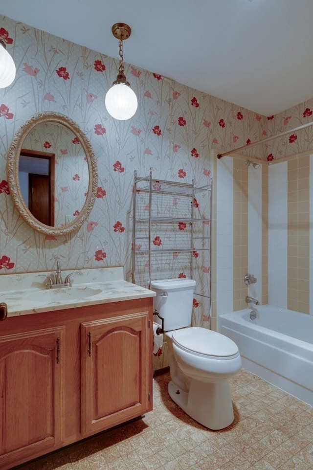 full bathroom featuring tiled shower / bath, vanity, and toilet