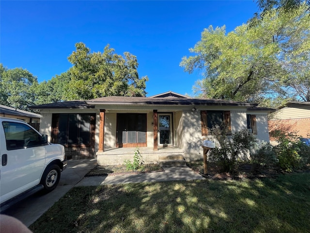 single story home with covered porch and a front lawn