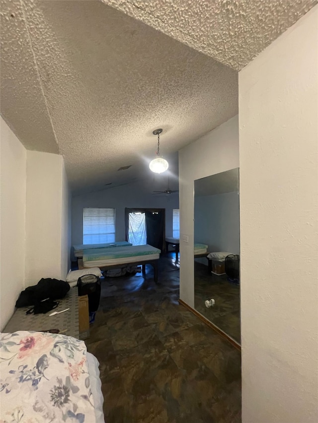 bedroom featuring a textured ceiling and vaulted ceiling