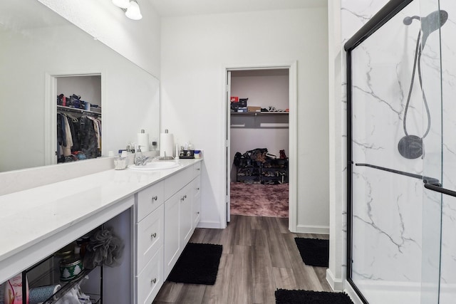 bathroom featuring hardwood / wood-style floors, vanity, and a shower with shower door