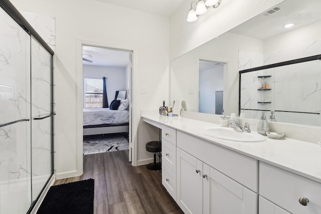 bathroom with hardwood / wood-style flooring, vanity, and a shower with shower door