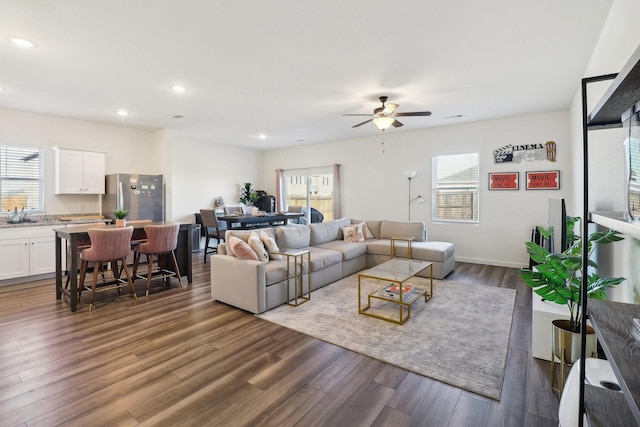 living room with ceiling fan and dark wood-type flooring