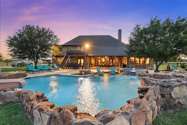 12201 Madison Ln, Justin, TX 76247 - pool at dusk with an in-ground hot tub, a water slide, stairs, and an outdoor pool
