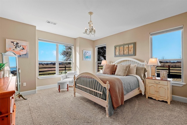 bedroom with light colored carpet and a notable chandelier