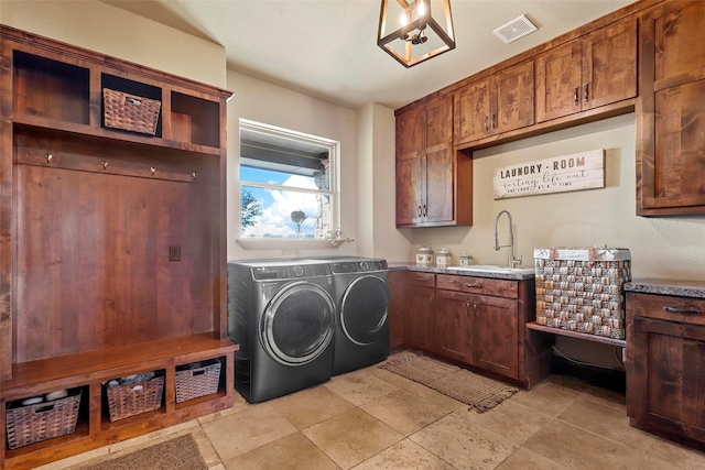 clothes washing area with sink, cabinets, and independent washer and dryer