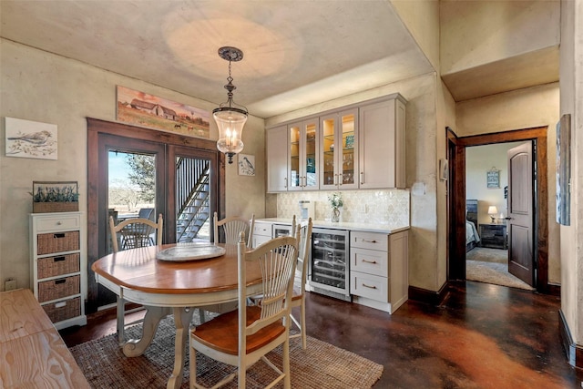 12201 Madison Ln, Justin, TX 76247 - dining space featuring wine cooler, finished concrete flooring, a bar, and baseboards