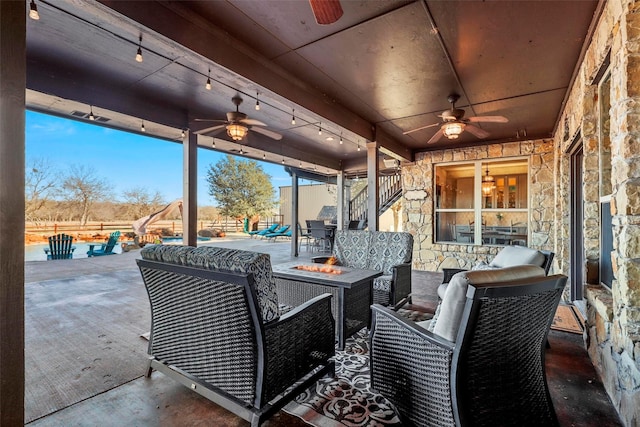 view of patio / terrace with ceiling fan and an outdoor fire pit