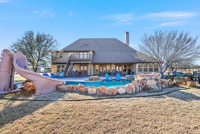 back of property with a balcony, a yard, and a patio area