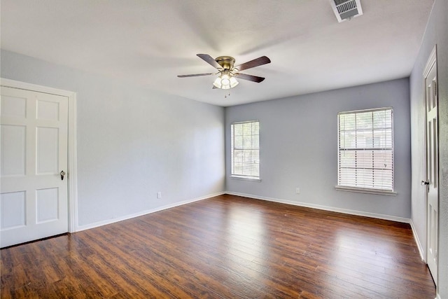 empty room with dark hardwood / wood-style flooring and ceiling fan