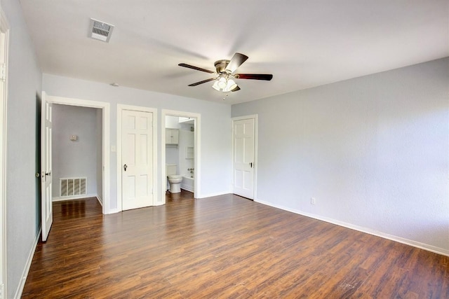 unfurnished bedroom with ensuite bathroom, dark hardwood / wood-style floors, and ceiling fan