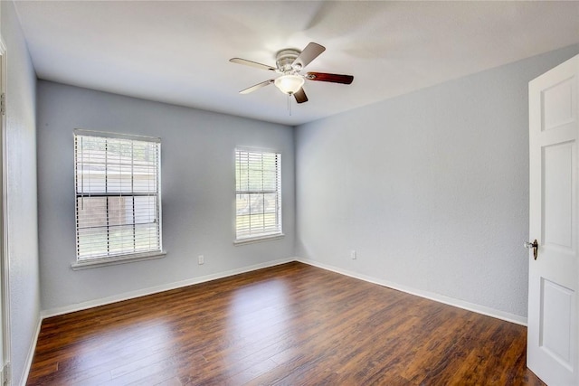 spare room featuring dark hardwood / wood-style flooring and ceiling fan