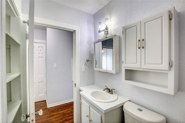 bathroom featuring vanity, hardwood / wood-style floors, and toilet