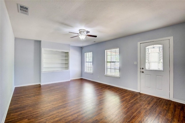 entryway featuring dark wood-type flooring, ceiling fan, and a textured ceiling