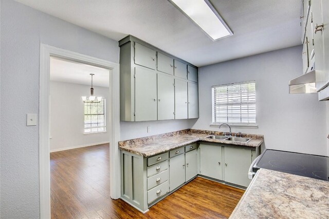 kitchen with gray cabinets, light wood-type flooring, stainless steel electric range oven, and sink