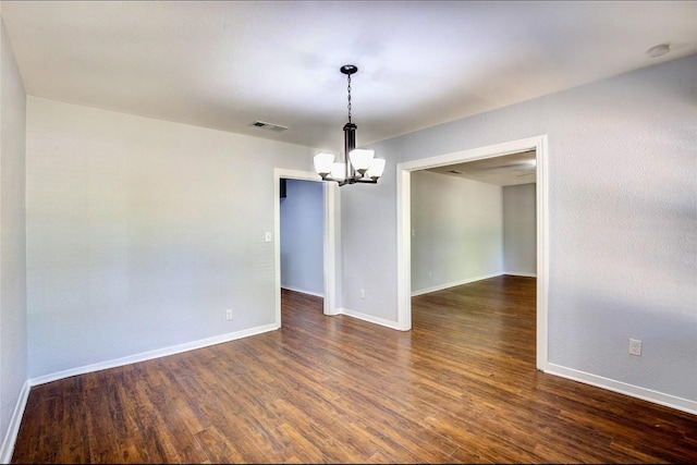 708 N US Highway 69, Celeste, TX 75423 - spare room featuring baseboards, dark wood-type flooring, visible vents, and a chandelier
