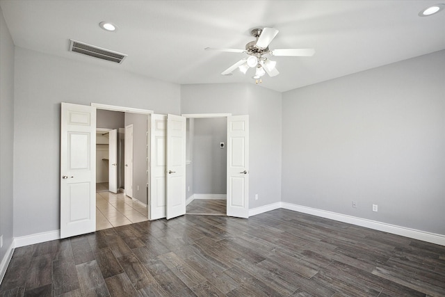 unfurnished bedroom featuring dark hardwood / wood-style floors and ceiling fan