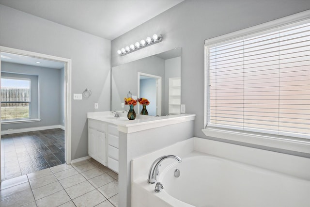 bathroom with vanity, a washtub, and tile patterned floors