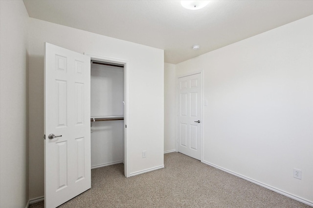 unfurnished bedroom with light colored carpet and a closet