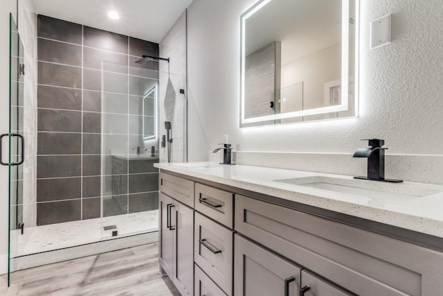 bathroom featuring a shower with door, vanity, and hardwood / wood-style flooring