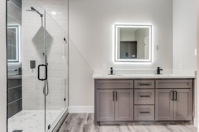 bathroom with a shower with door, vanity, and hardwood / wood-style flooring