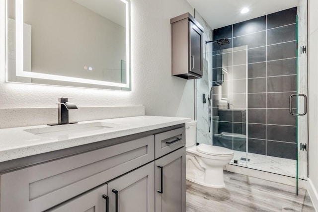 bathroom featuring vanity, toilet, a shower with shower door, and wood-type flooring