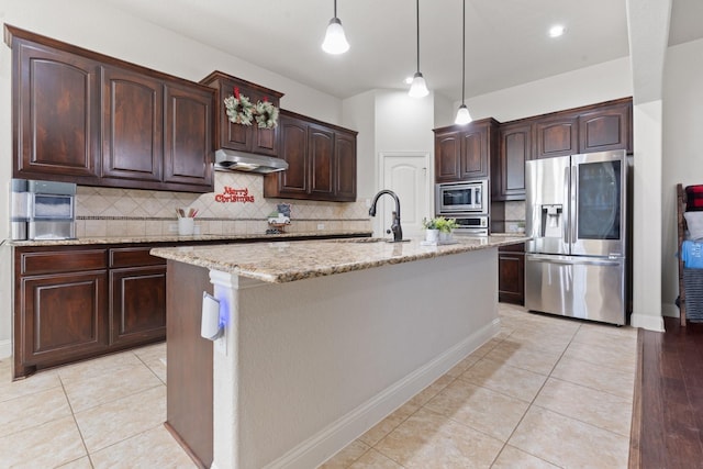 kitchen featuring appliances with stainless steel finishes, hanging light fixtures, light tile patterned floors, dark brown cabinetry, and a center island with sink